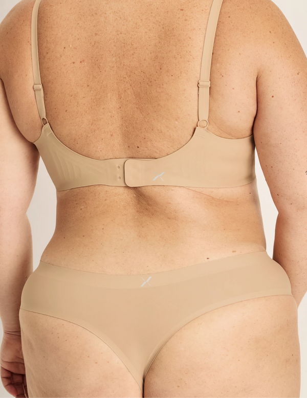 Clementine has 51” hips, and wearing KNIX XXL | Back view of model wearing the Essential No-Show Thong highlighting the coverage and smooth fit | Warm Sand