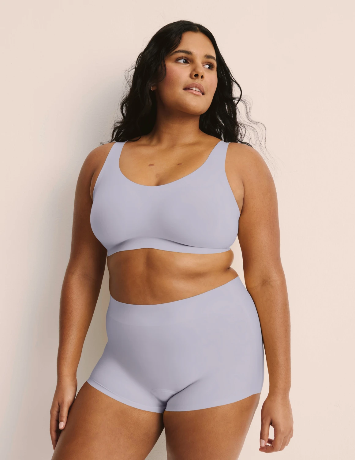 Adiya is a 36C and wearing KNIX L | Full-body view of model wearing the Revolution Adjustable Pullover Bra, highlighting the neckline, strap design, and  silhouette | Lavender
