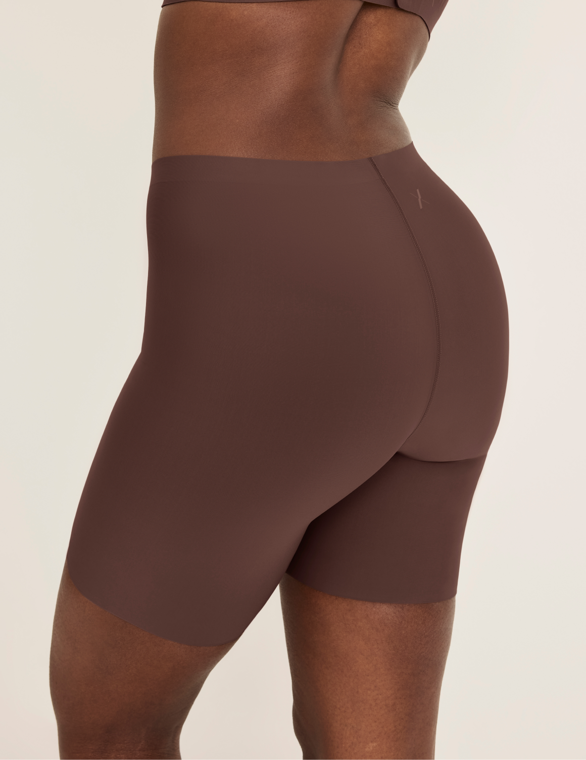 Orlane is wearing KNIX S | Side view of model wearing the Thigh Saver® 6” highlighting the coverage and smooth fit | Sable
