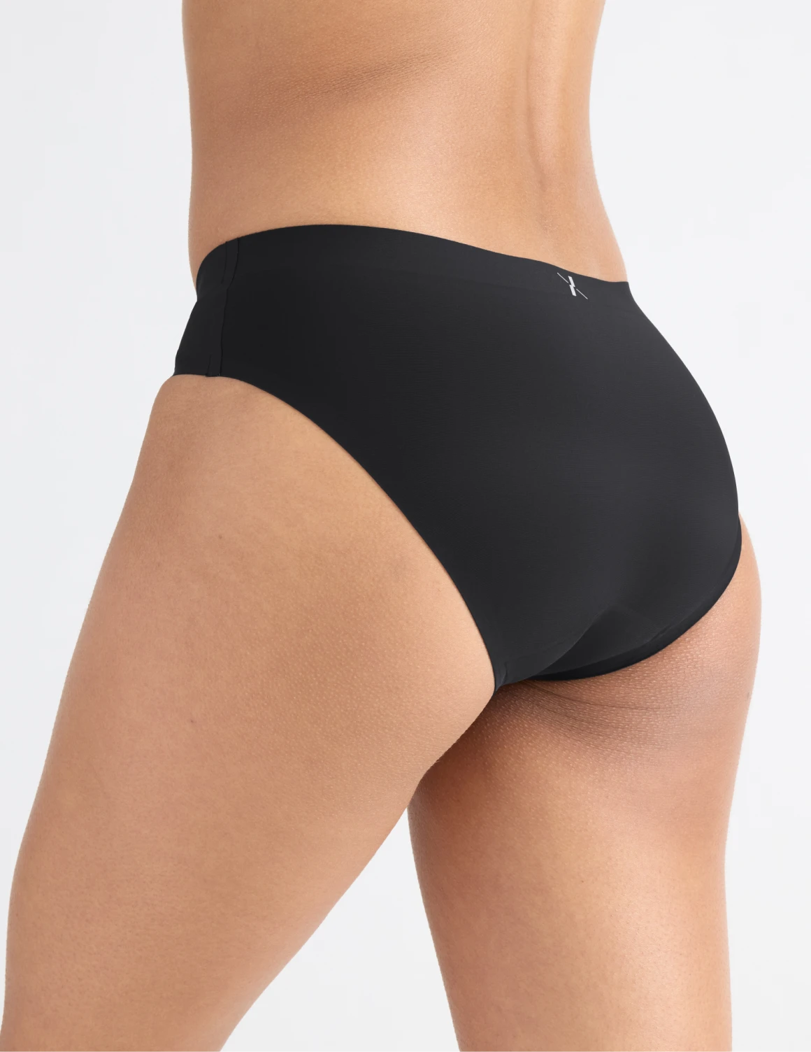 Tsanna has 34.5” hips and wearing KNIX S | Back view of model wearing the Leakproof UltraThin No-Show Bikini highlighting the coverage and smooth fit | Black