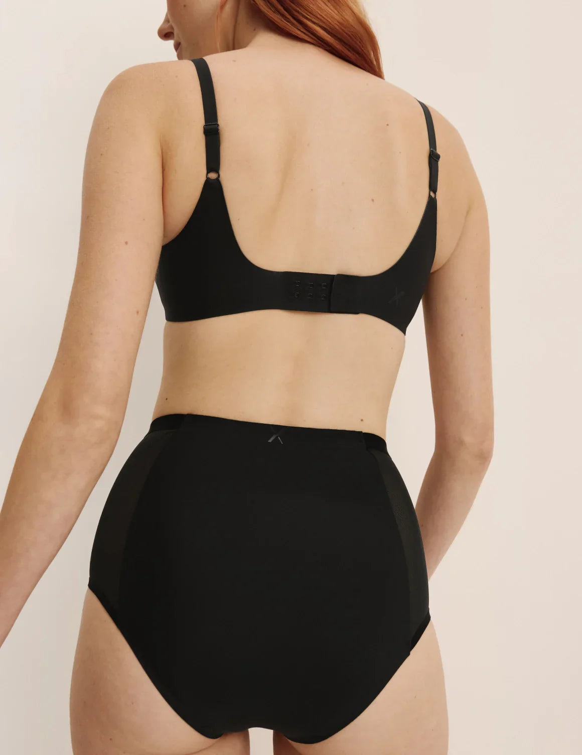 Molly is a 30B wearing KNIX XS | Back view of model wearing the Revolution Shadow Mesh Bra, highlighting the neckline, strap design, and  silhouette | Black