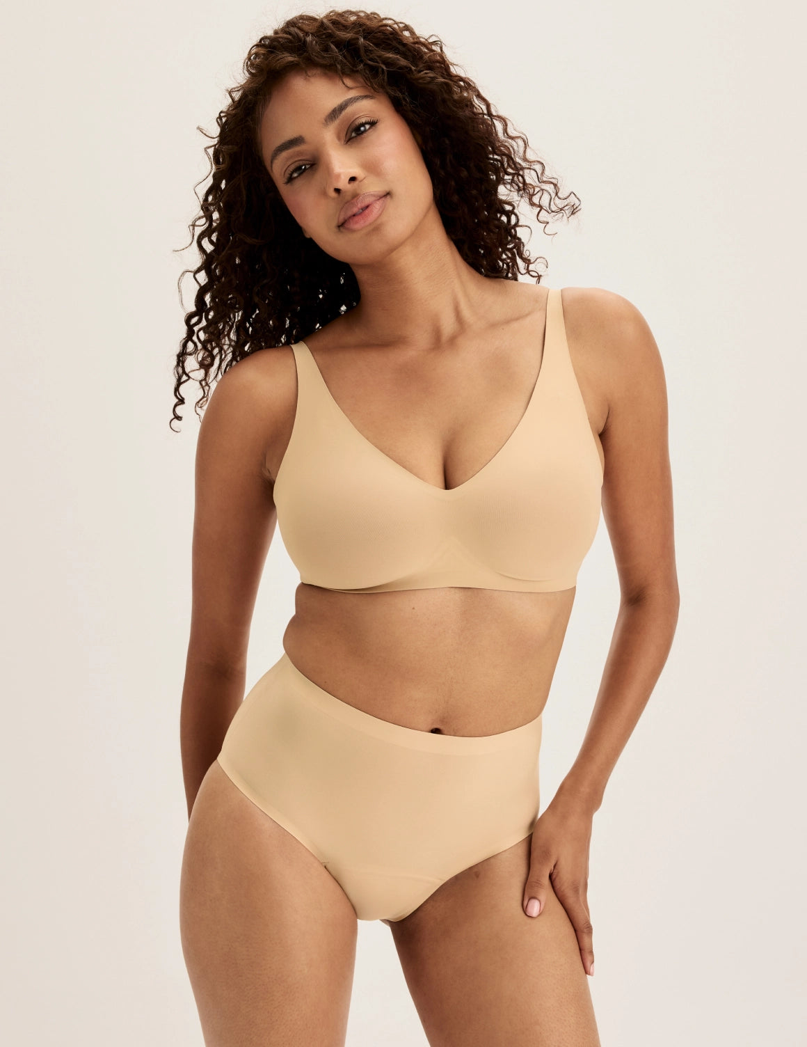 Ashley has 39” hips and wears KNIX S | Full-body view of model wearing the Super Leakproof® No-Show High Rise highlighting the coverage and smooth fit | Warm Sand